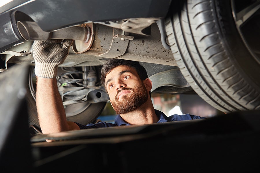 technician repairing car exhaust